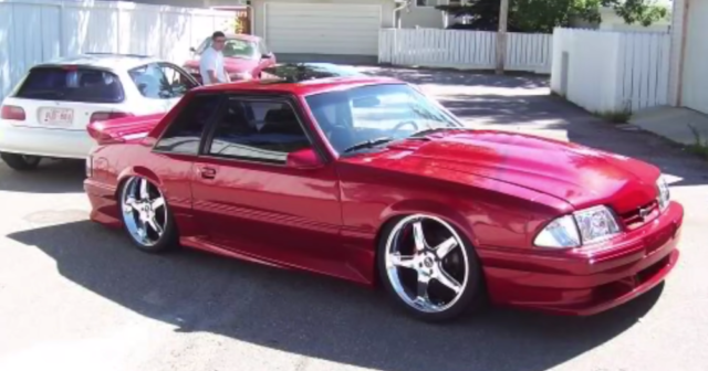 Fox Body Mustang on 20-inch rims.